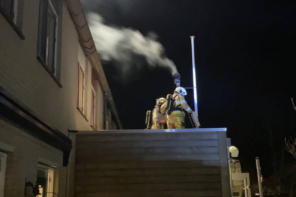 Brand in schoorsteenpijp van palletkachel achter woning