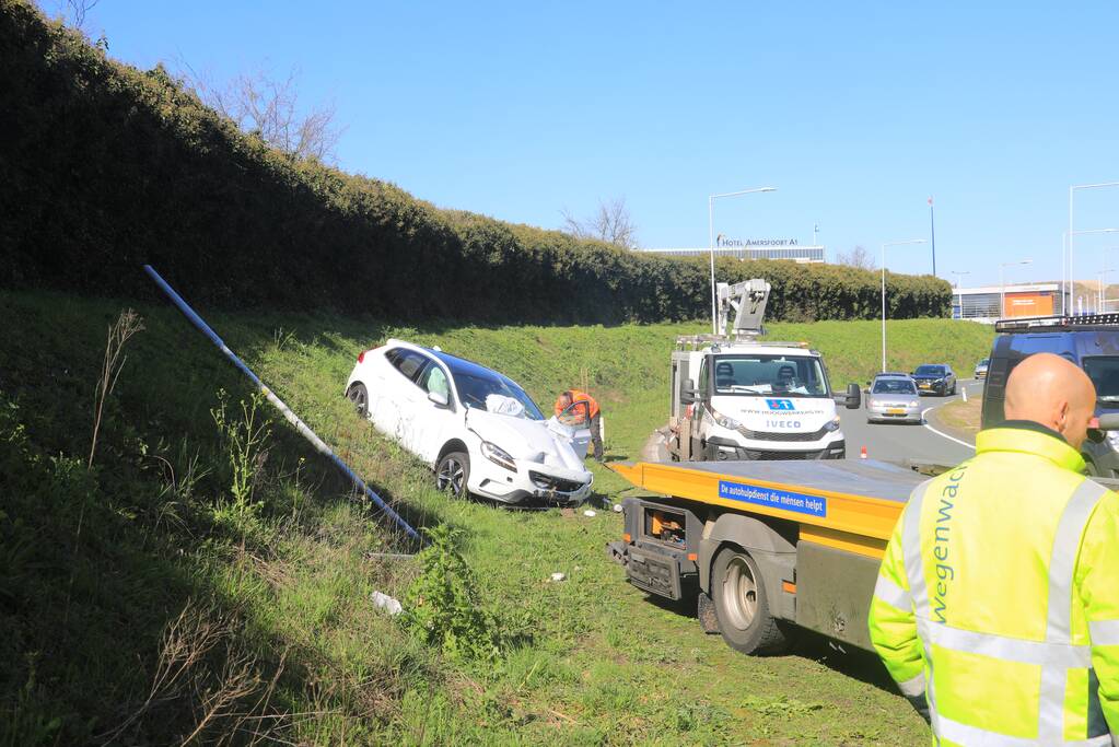 Auto vliegt uit de bocht en belandt op geluidswal