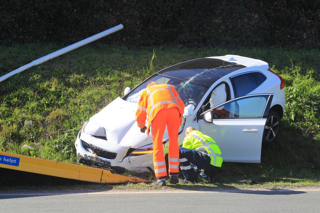 Auto vliegt uit de bocht en belandt op geluidswal