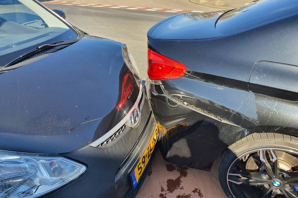Auto botst op stilstaande auto op kruising