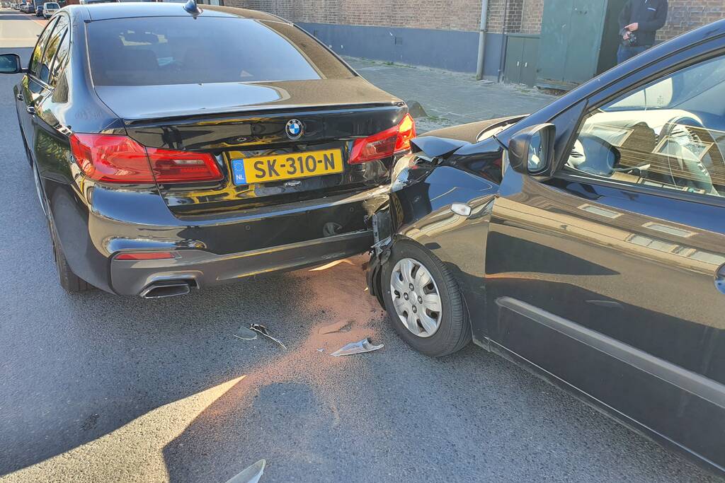 Auto botst op stilstaande auto op kruising