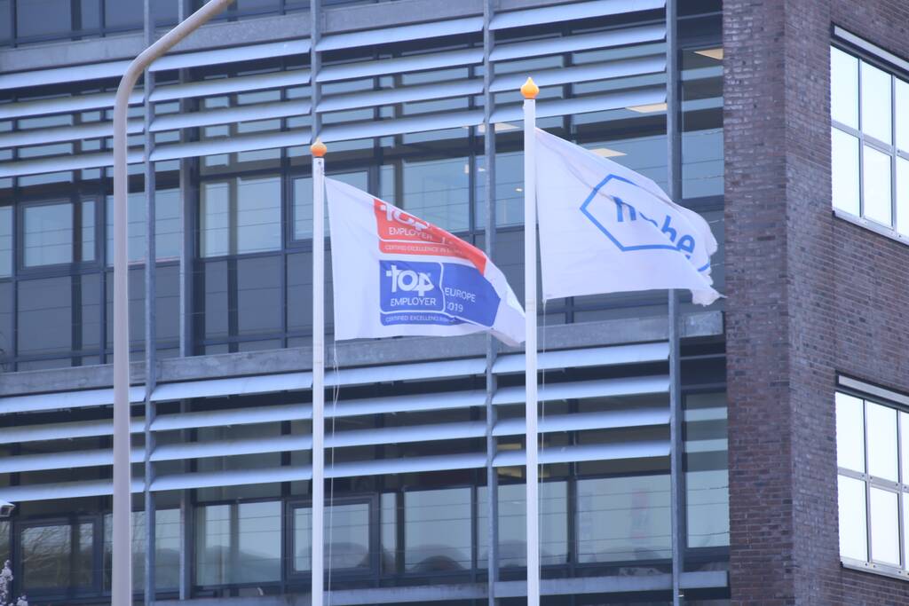 Kantoorpand farmaceut Roche beklad met leuzen