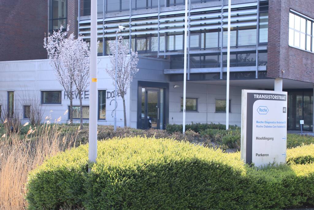 Kantoorpand farmaceut Roche beklad met leuzen