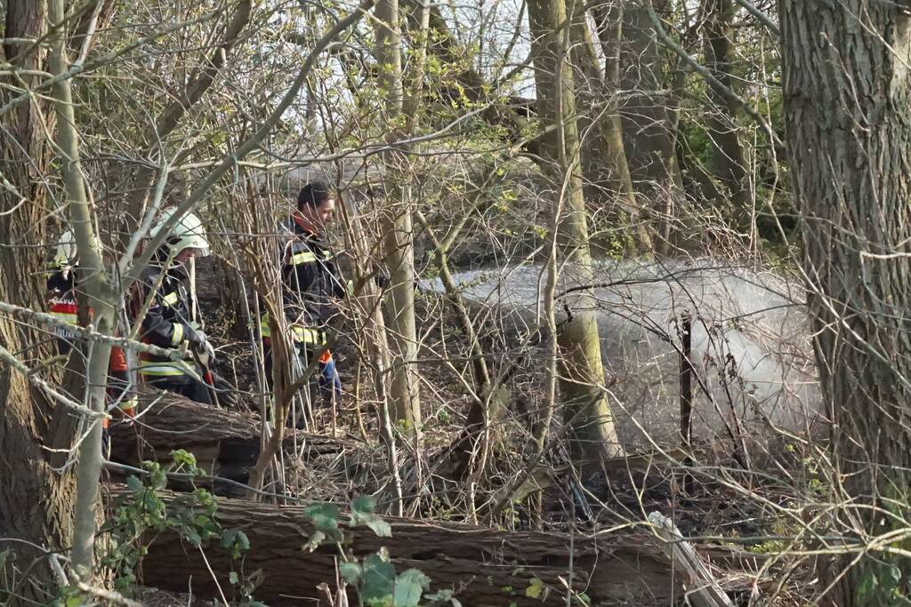 Bosschage langs rivier de Lek in brand