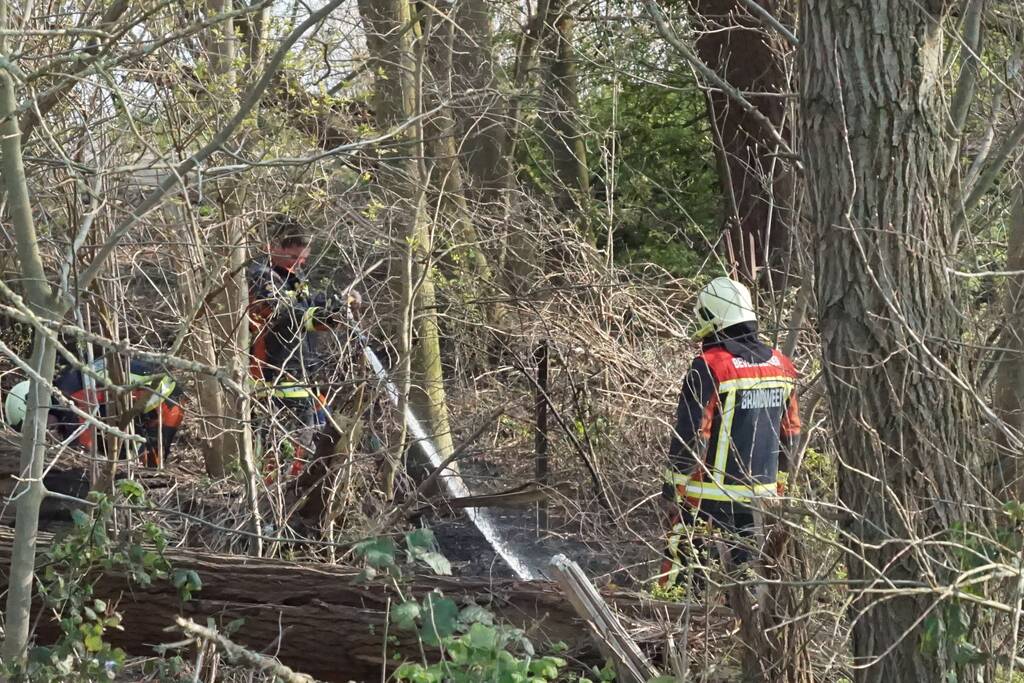 Bosschage langs rivier de Lek in brand