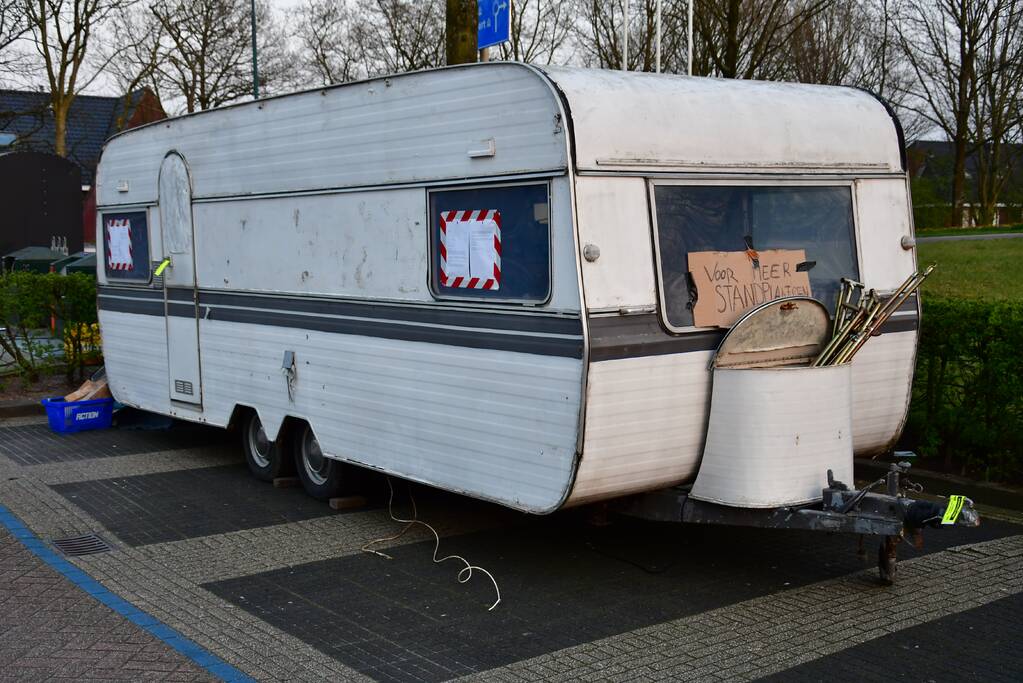 Handhaving sleept caravan met protesttekst weg van parkeerterrein gemeentewerf