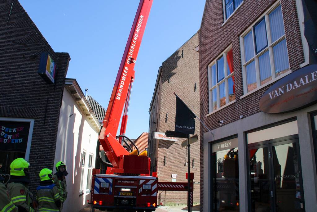 Brandweer verwijdert losliggende dakpannen winkelpand