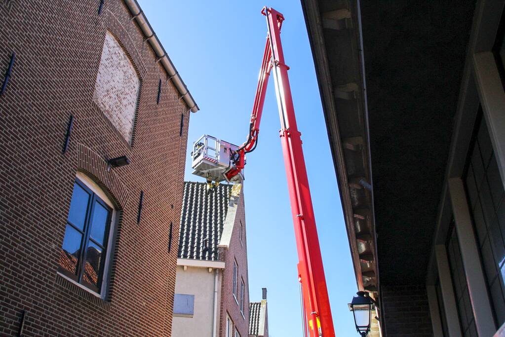 Brandweer verwijdert losliggende dakpannen winkelpand