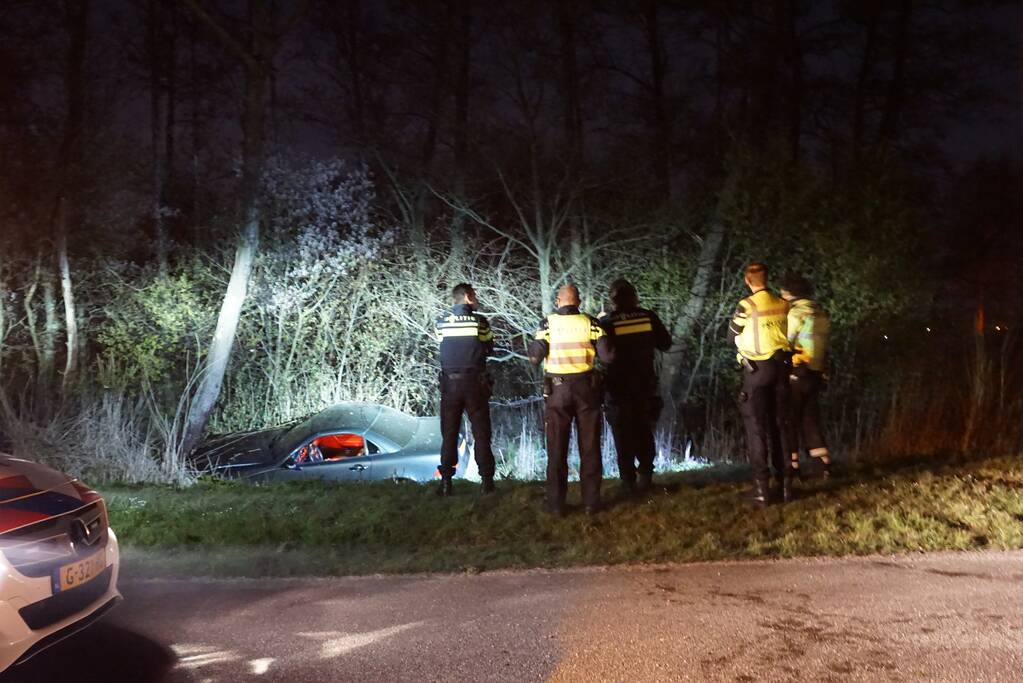 Auto te water, inzittende gewond