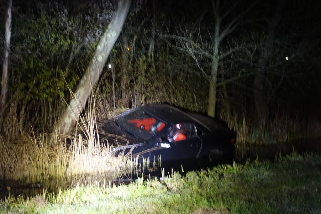 Auto te water, inzittende gewond