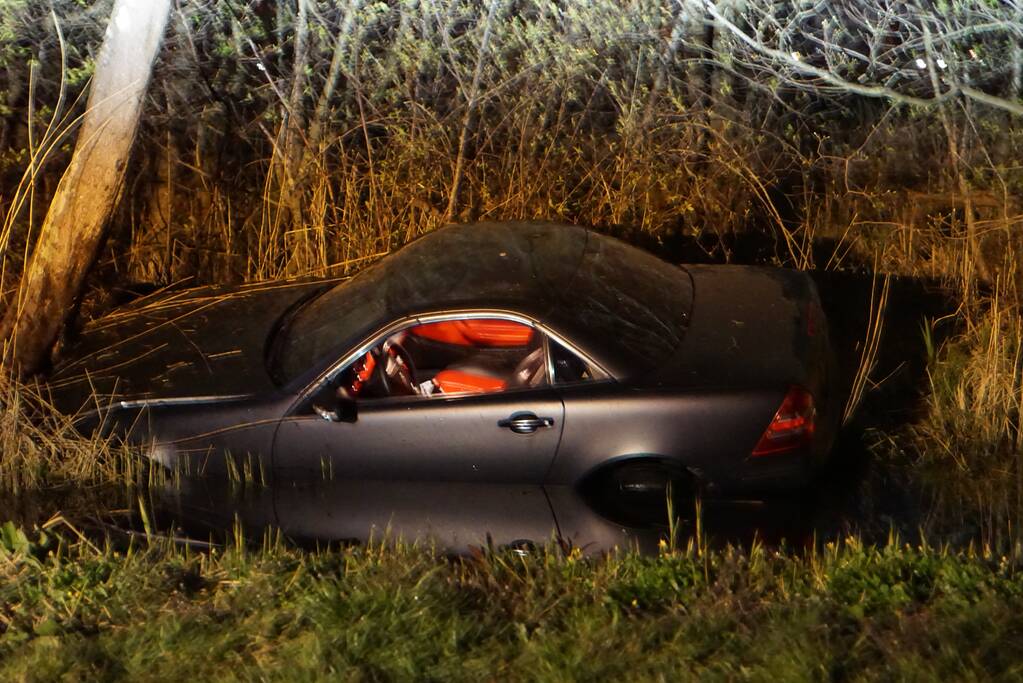 Auto te water, inzittende gewond