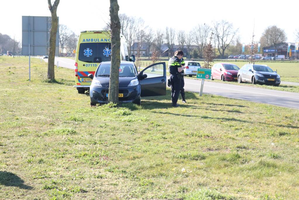 Auto botst op boom, inzittende bekneld
