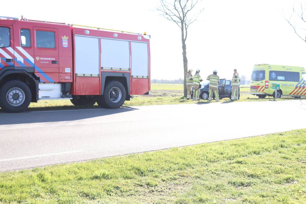 Auto botst op boom, inzittende bekneld