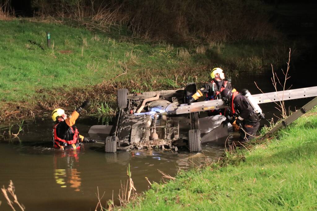 Auto te water bestuurder neemt de benen