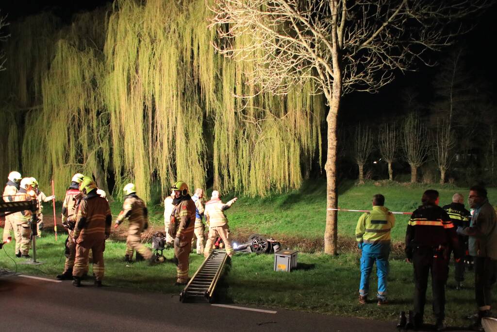 Auto te water bestuurder neemt de benen