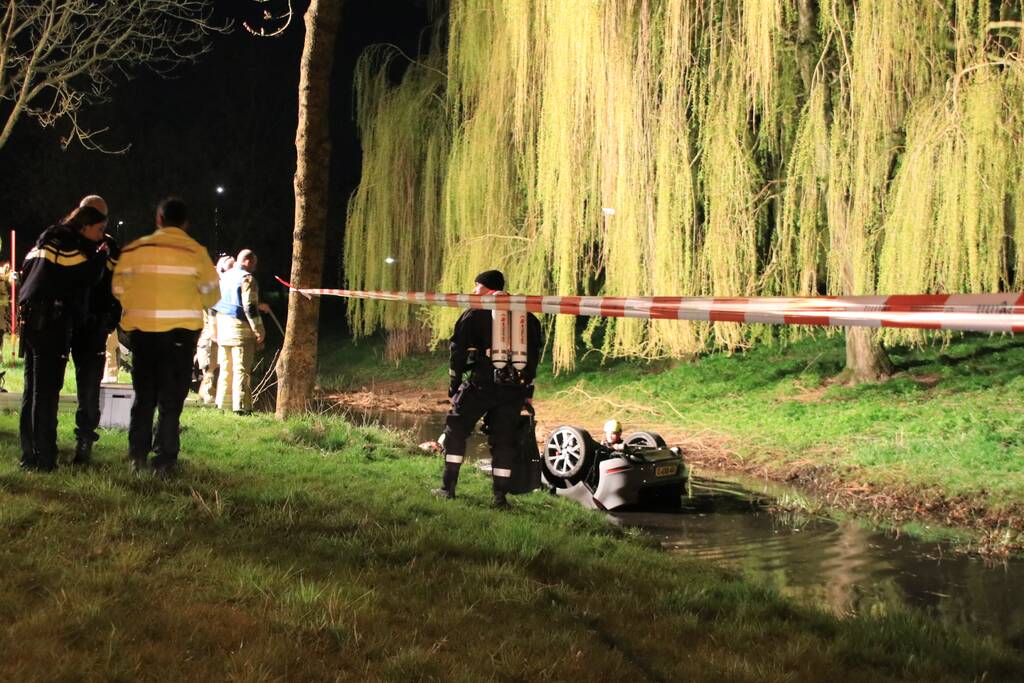 Auto te water bestuurder neemt de benen