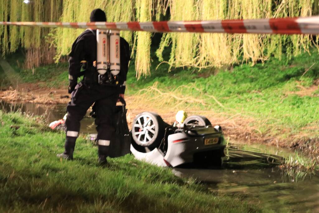 Auto te water bestuurder neemt de benen