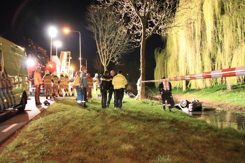 Auto te water bestuurder neemt de benen