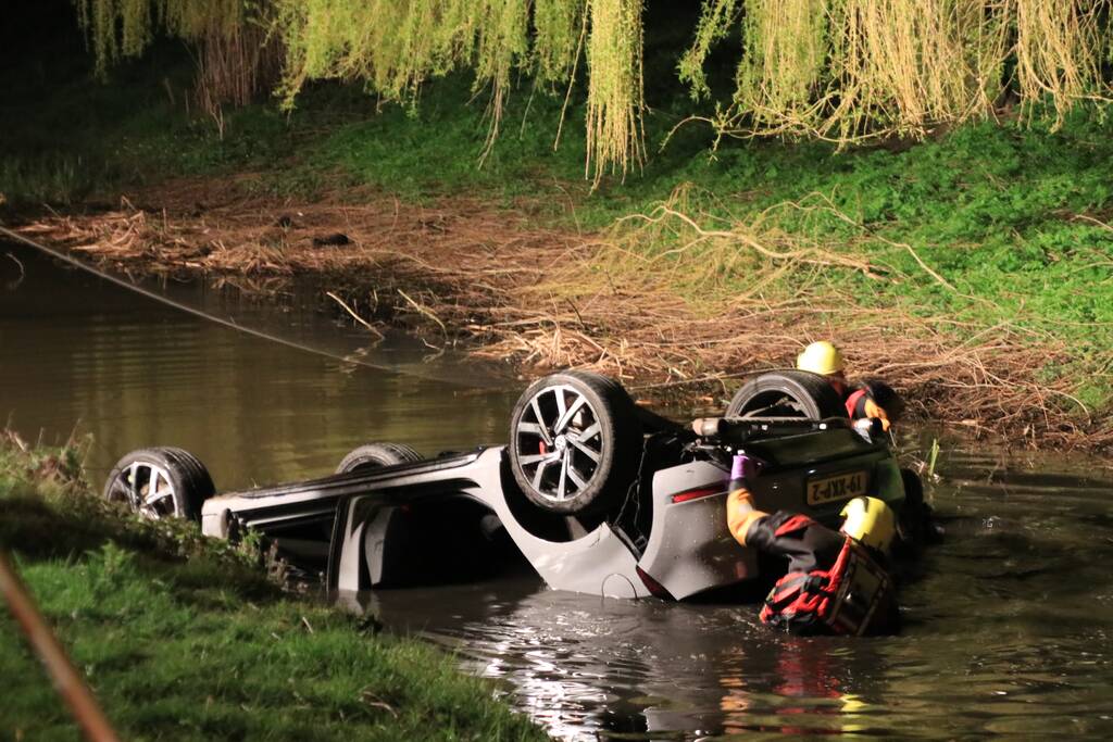 Auto te water bestuurder neemt de benen