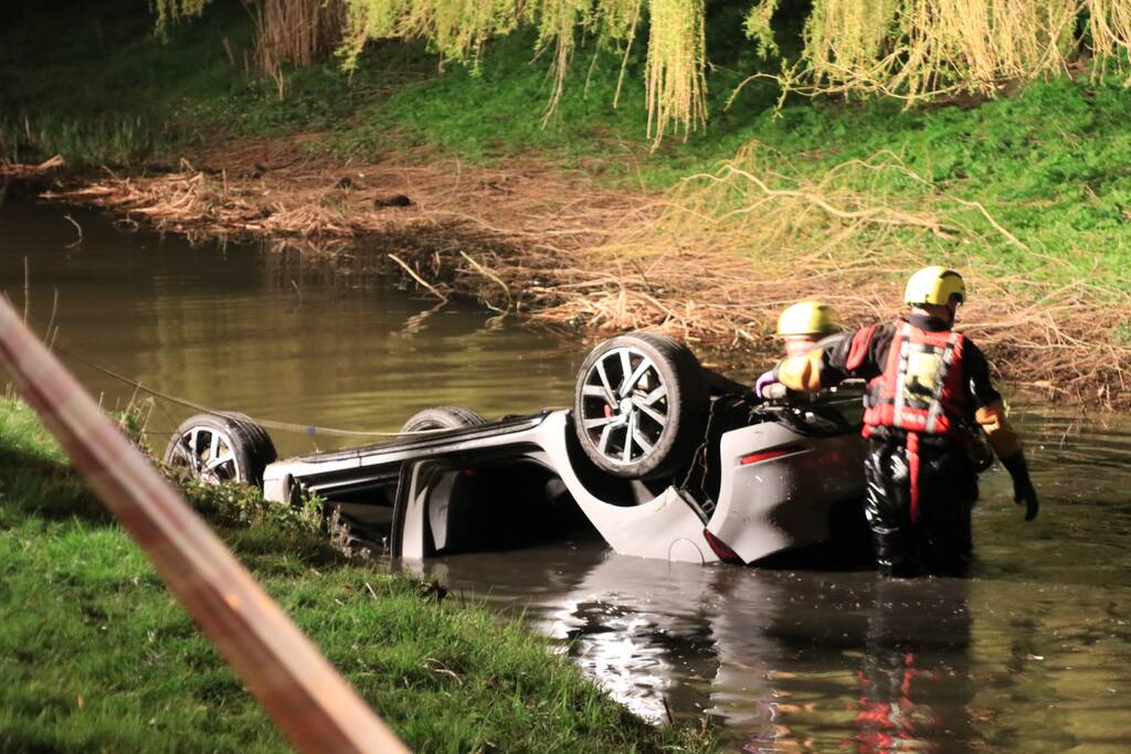 Auto te water bestuurder neemt de benen