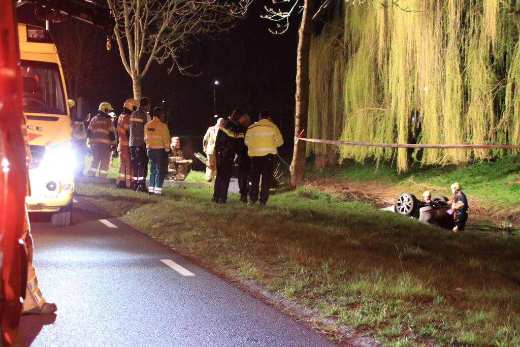 Auto te water bestuurder neemt de benen