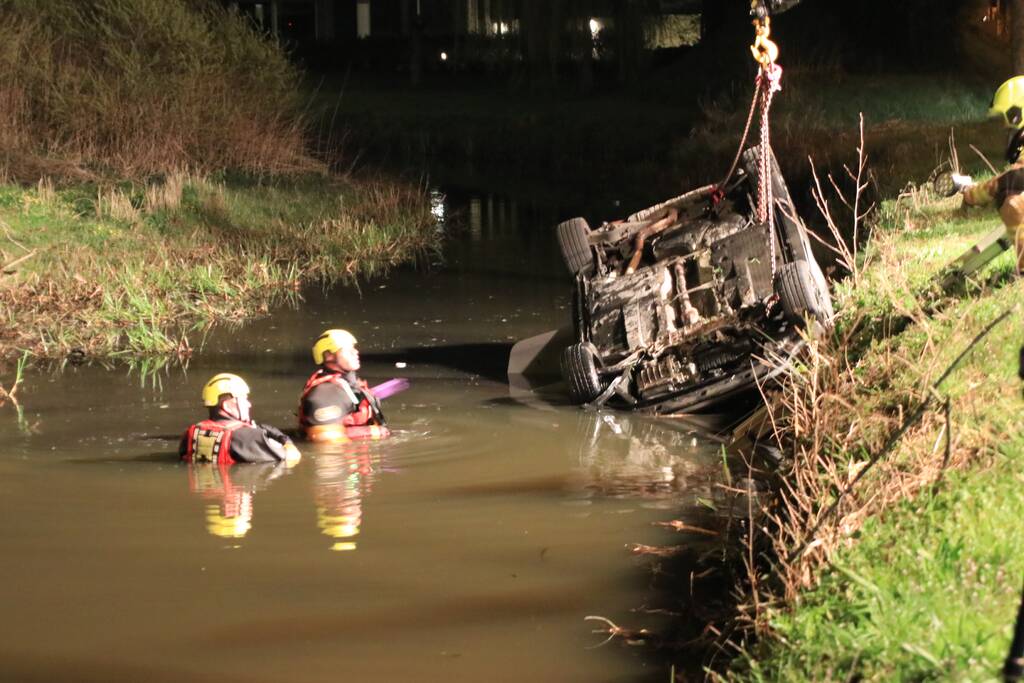 Auto te water bestuurder neemt de benen