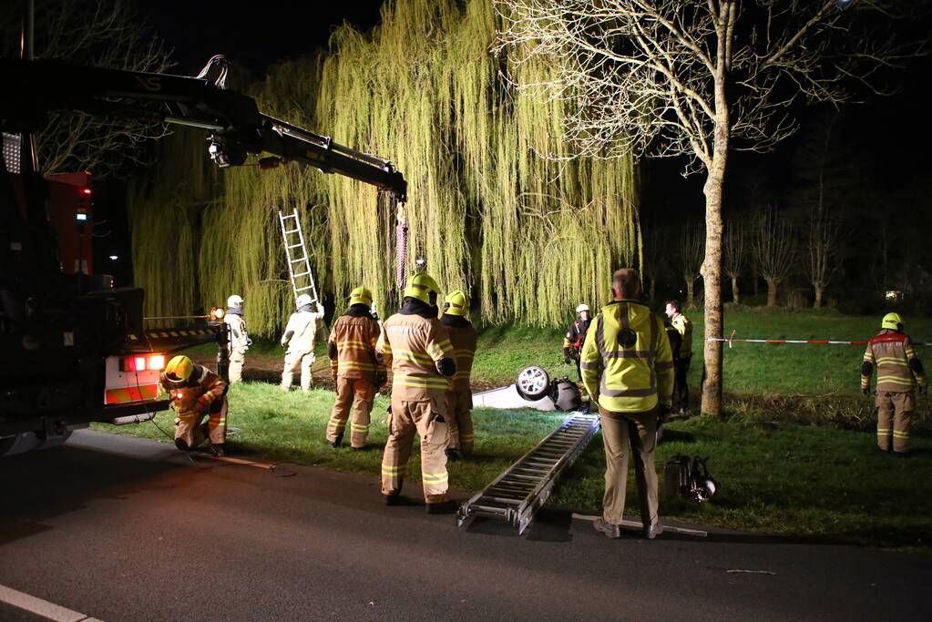 Auto te water bestuurder neemt de benen