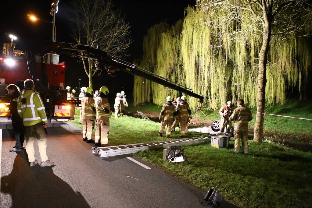 Auto te water bestuurder neemt de benen