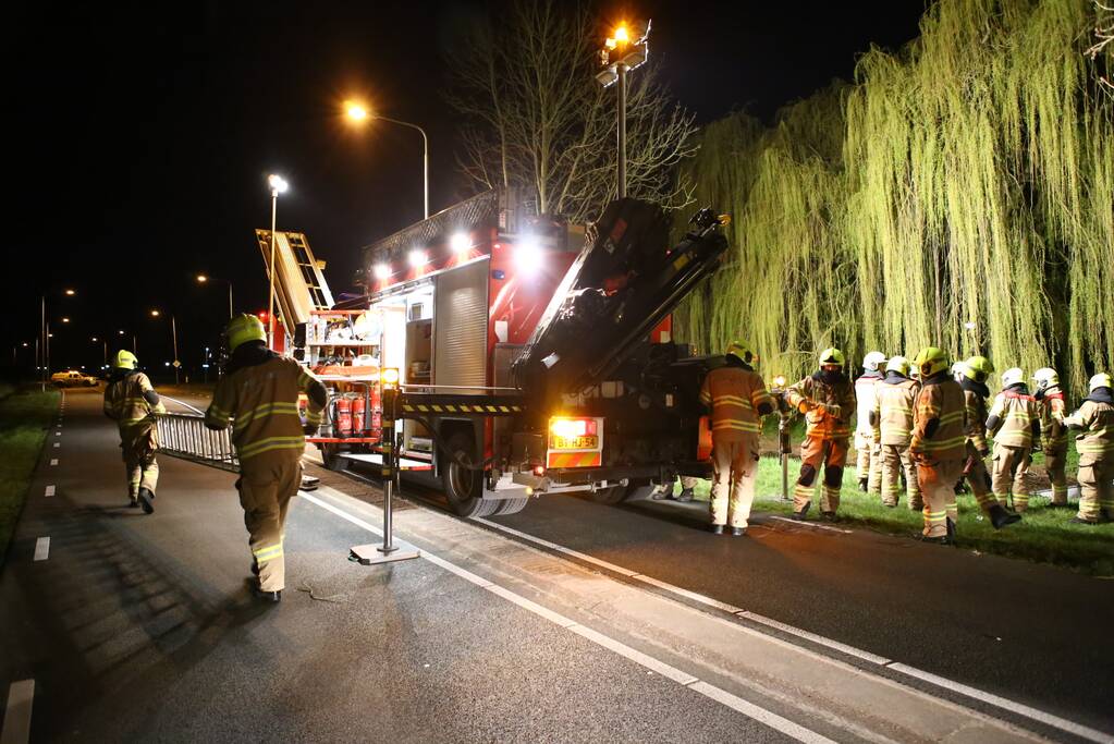 Auto te water bestuurder neemt de benen