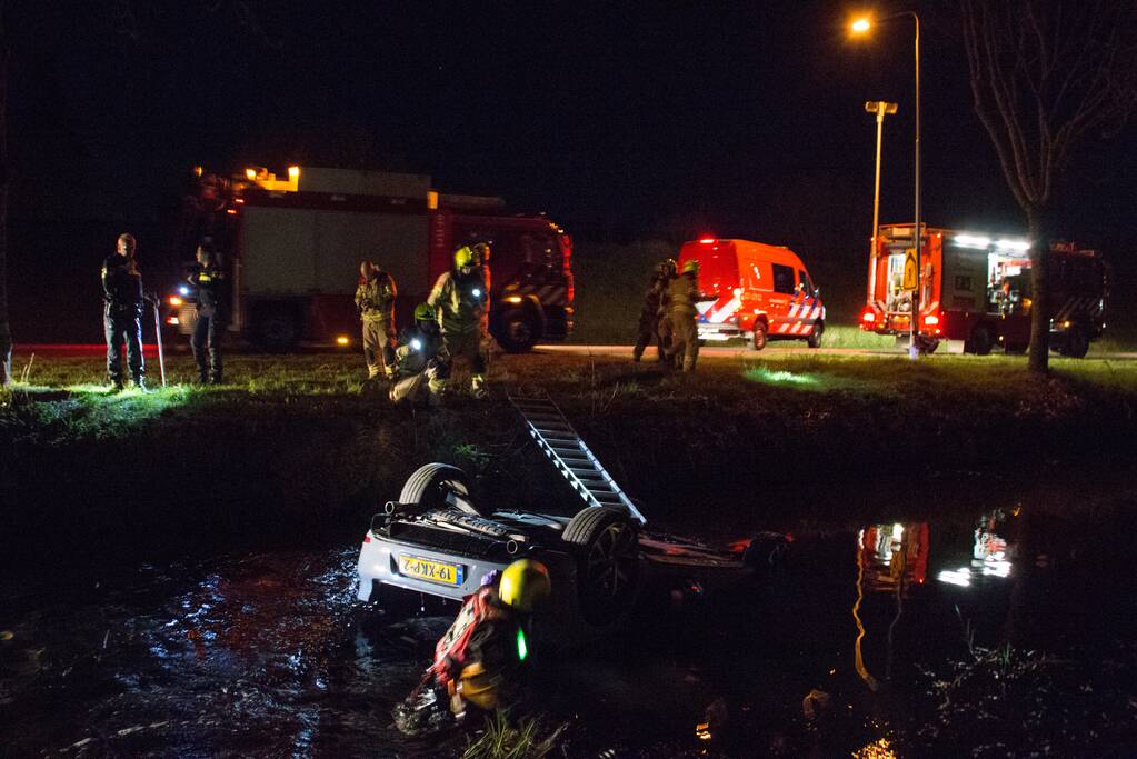 Auto te water bestuurder neemt de benen