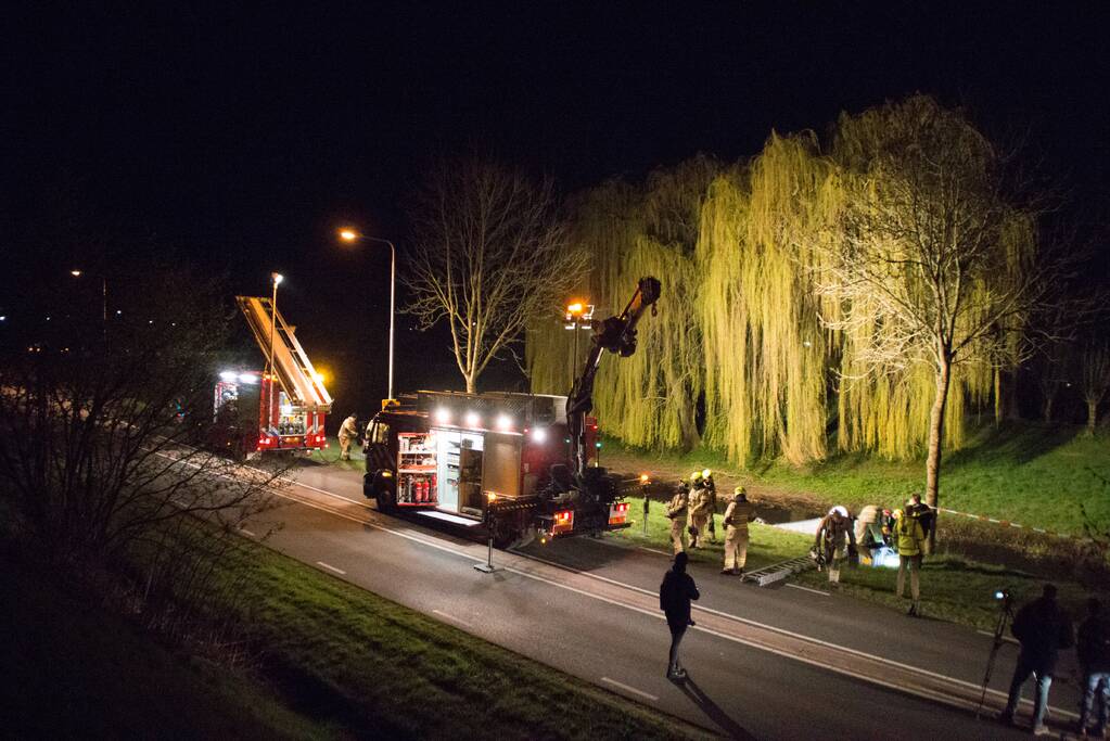 Auto te water bestuurder neemt de benen