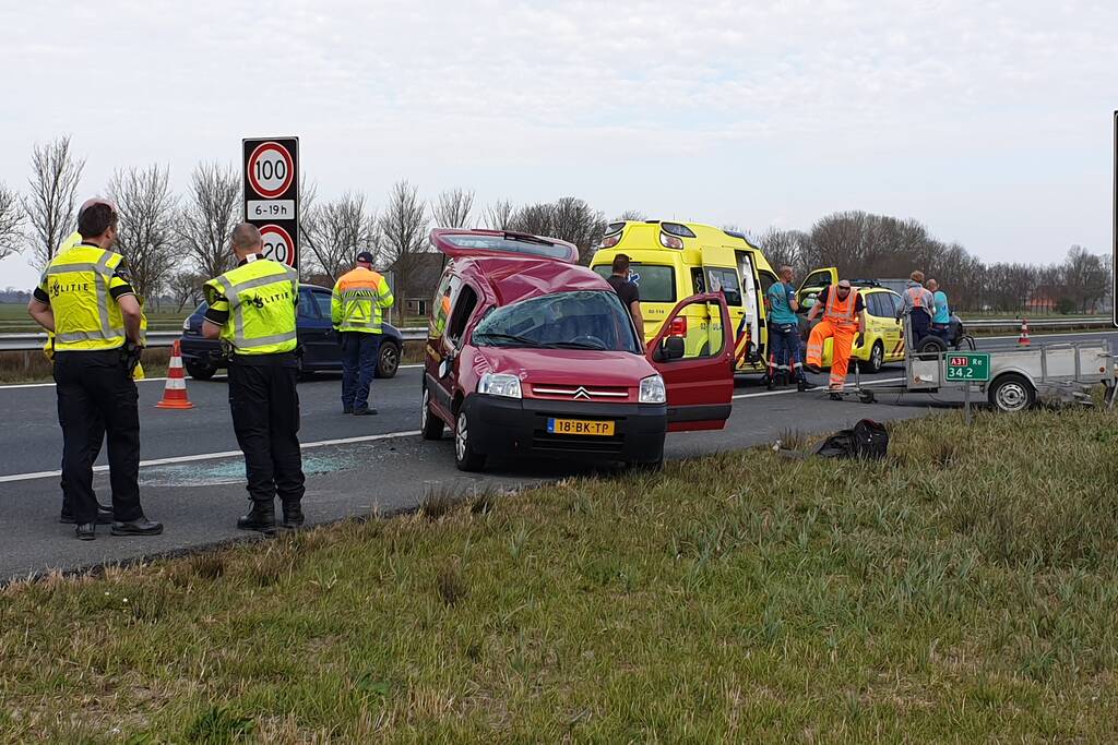 Bestelbus met aanhanger slaat over de kop