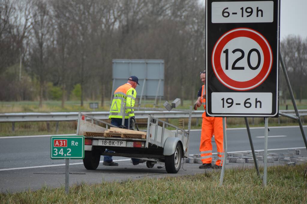 Bestelbus met aanhanger slaat over de kop