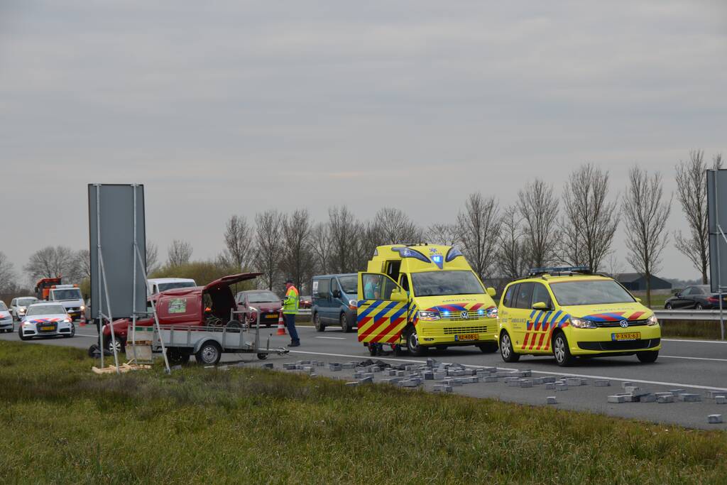 Bestelbus met aanhanger slaat over de kop