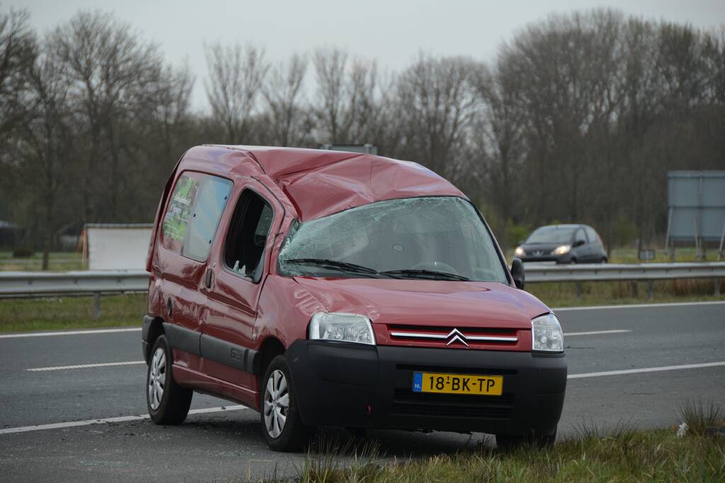 Bestelbus met aanhanger slaat over de kop