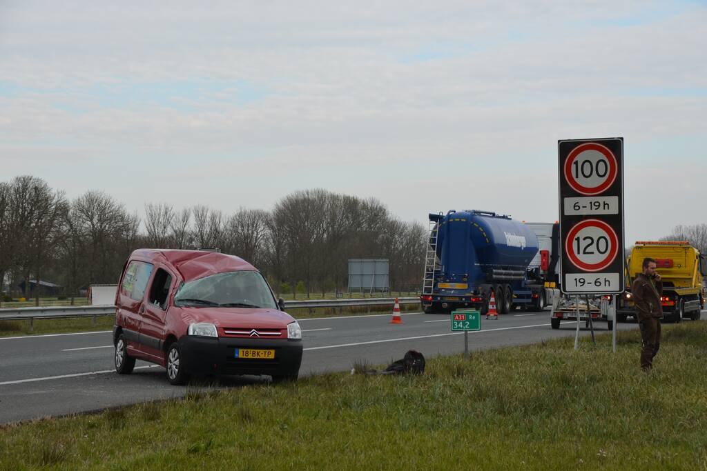 Bestelbus met aanhanger slaat over de kop