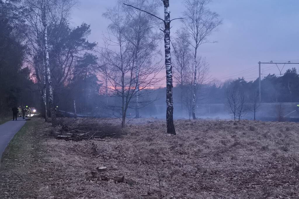 Groot stuk bosschage langs spoor in brand