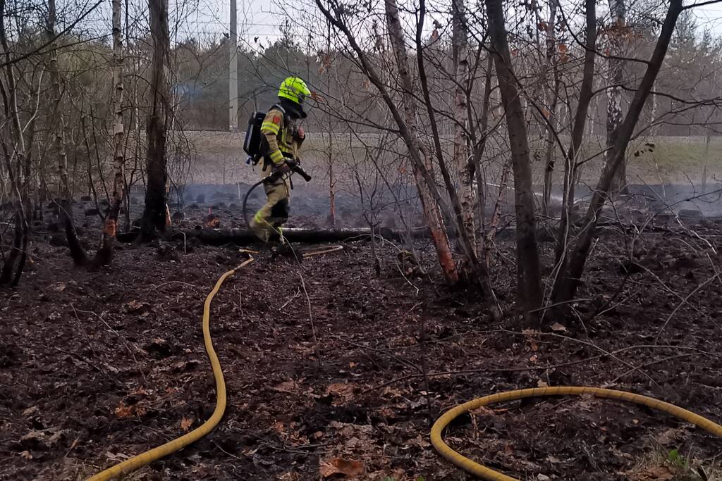 Groot stuk bosschage langs spoor in brand