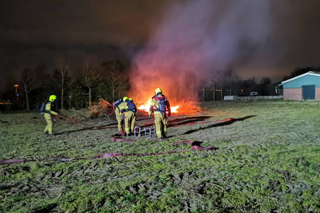Berg met takken in weiland vatte vlam