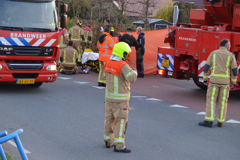 Man bekneld onder as van bedrijfswagen