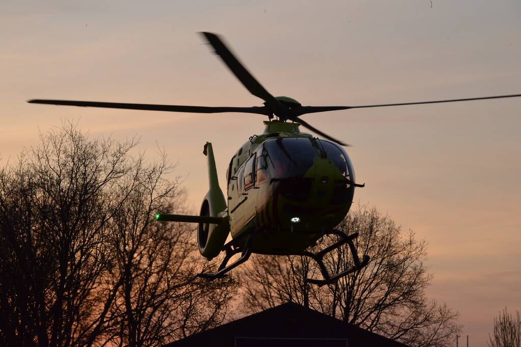 Man bekneld onder as van bedrijfswagen