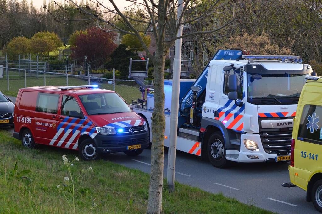 Man bekneld onder as van bedrijfswagen