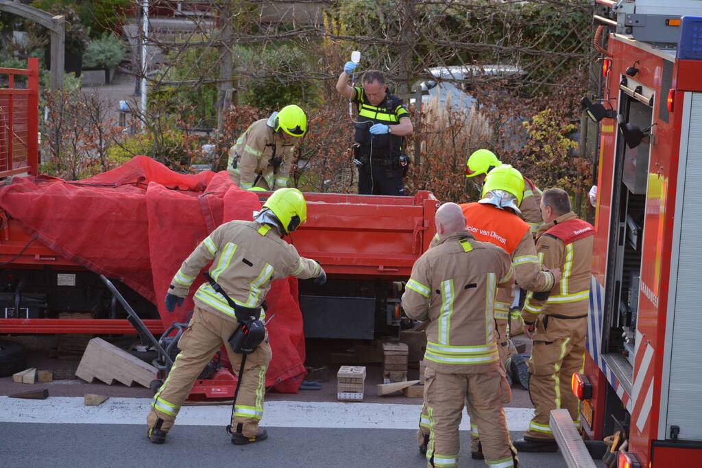 Man bekneld onder as van bedrijfswagen