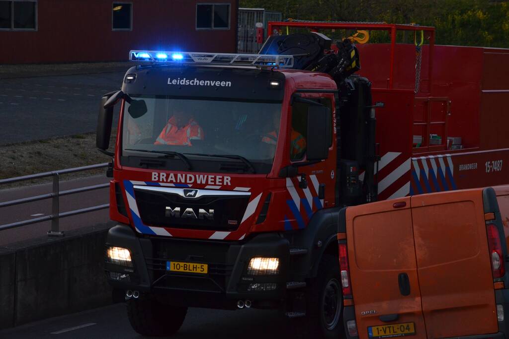 Man bekneld onder as van bedrijfswagen