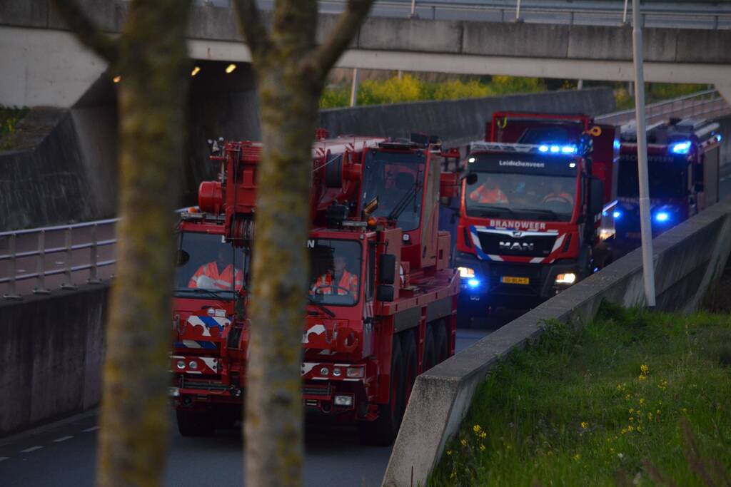 Man bekneld onder as van bedrijfswagen