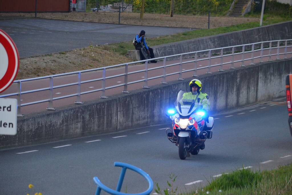 Man bekneld onder as van bedrijfswagen