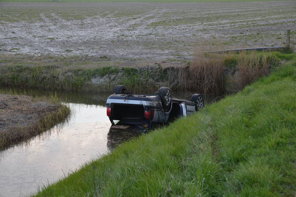 Auto op zijn kop in de sloot