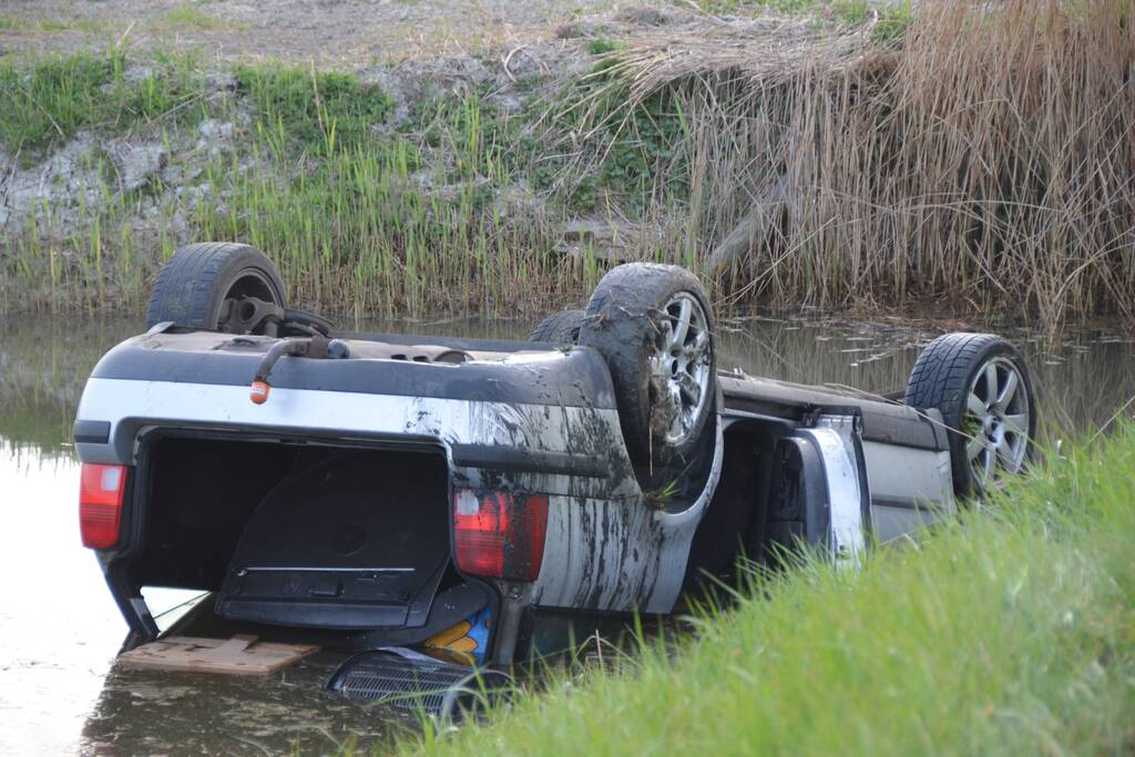 Auto op zijn kop in de sloot