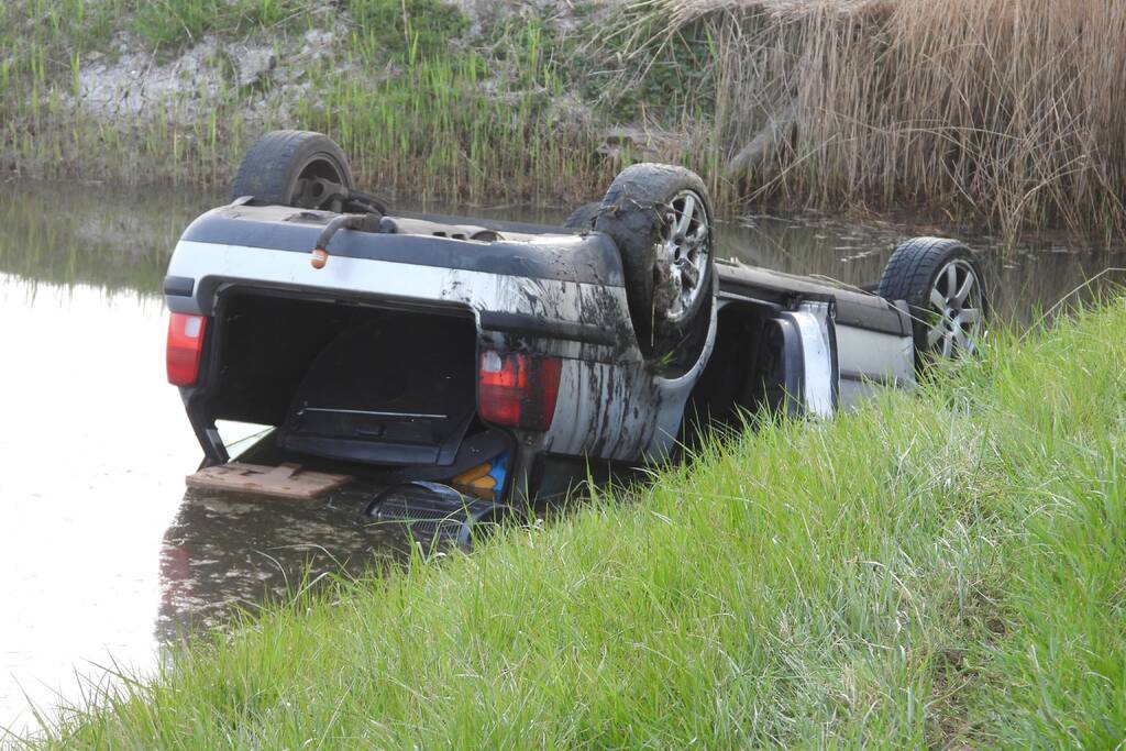Auto op zijn kop in de sloot