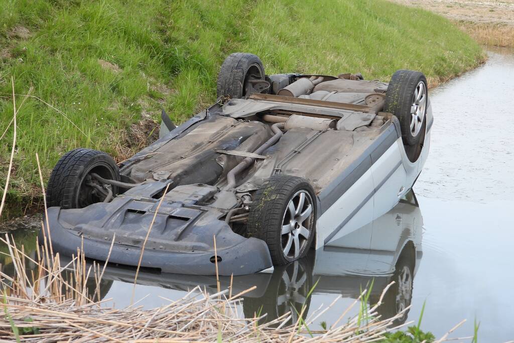 Auto op zijn kop in de sloot